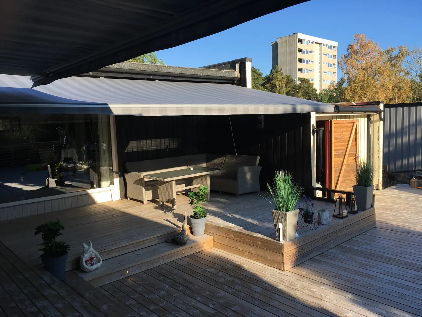 Terrassemarkise fra REX på et lyst trehus